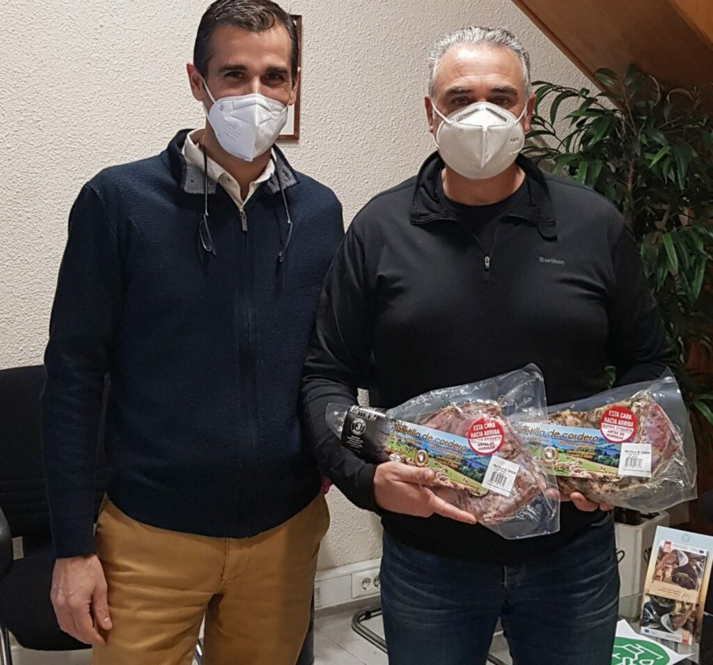 Carlos Romero ganador del sorteo de las 2 paletillas marinadas de CARNES FRESCAS, S.A. recogiéndolas de mano del gerente Alberto Jorques